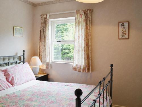 a bedroom with a bed and a window at Mallards in Wells next the Sea