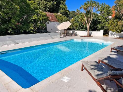 a swimming pool with blue water in a yard at Old Chapel Cottage in Dunster