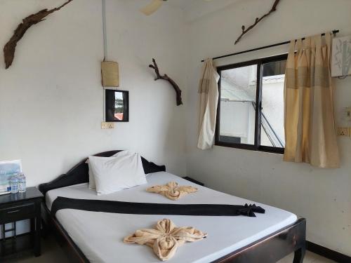 a bedroom with a bed with two towels on it at Auberge de la Plage in Kep
