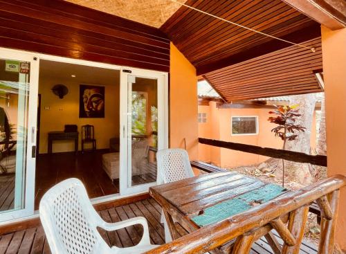 een houten tafel en stoelen op een veranda bij Paradise Palms in Ko Chang