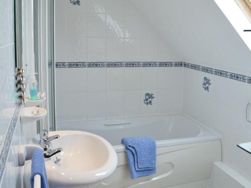a white bathroom with a sink and a tub at Sea Shells in Padstow