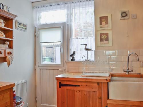 a kitchen with a sink and a window at Coble Cottage - 28317 in Flamborough