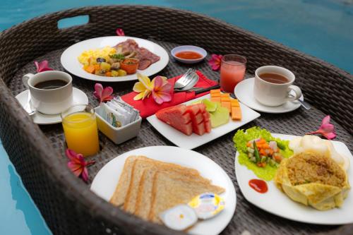 un tavolo con piatti per la colazione e tazze di caffè di Luxotic Private Villa and Resort a Nusa Dua