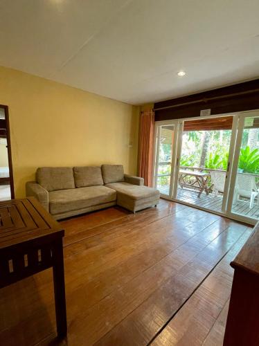 a living room with a couch and a sliding glass door at Paradise Palms in Ko Chang