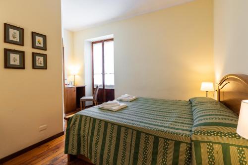 a hotel room with a bed with a green bedspread at Locanda Piemonte da Sciolla in Domodossola