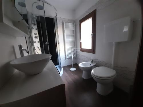 a bathroom with a sink and a toilet and a window at B&B La Tana Dei Ricci in Sestola