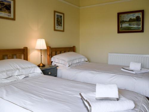 dwa łóżka w pokoju z białą pościelą w obiekcie Three Peaks House w mieście Horton in Ribblesdale