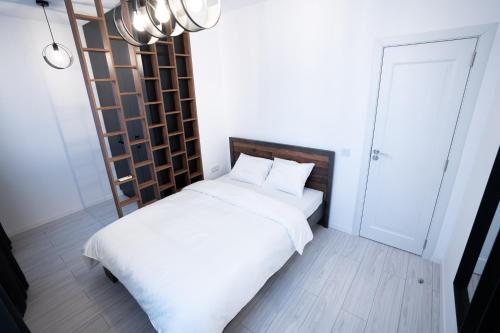 een slaapkamer met een wit bed en een ladder bij RCity Apartament 4 in Boekarest