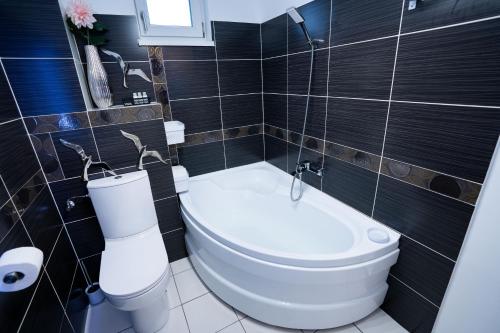 een badkamer met een wit toilet en een bad bij RCity Apartament 4 in Boekarest