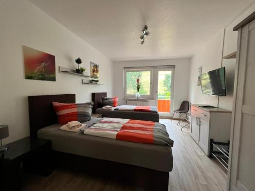 a bedroom with two beds and a television in it at Monteur- und Ferienwohnung in Neuenhof