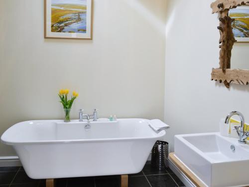 a bathroom with a white tub and a sink at Ty Hir in Aberdaron