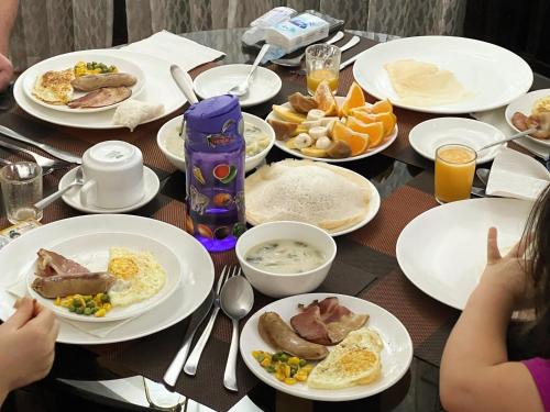 a table with plates of breakfast food on it at Reds Residency - Homestay in Cochin