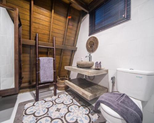 une salle de bain avec toilettes et lavabo dans l'établissement Rumah Kayu Tatiya Villa, à Jimbaran