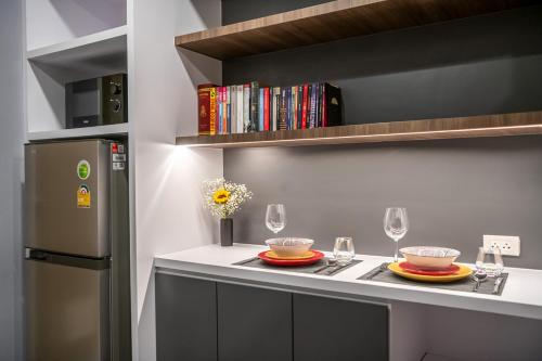 a kitchen with a counter with two plates and wine glasses at C2 stay Phayathai in Pom Prap