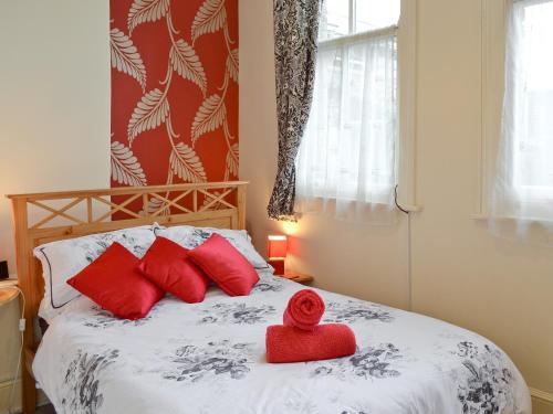 a bed with red pillows and a red rose on it at City 3 in York