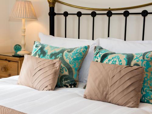 uma cama com almofadas azuis e brancas e um candeeiro em Sea Glimpse em Whitby