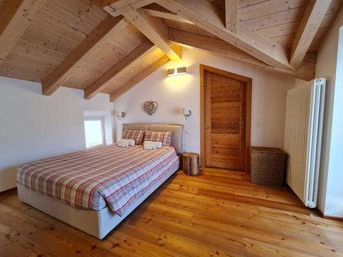 a bedroom with a bed and a wooden floor at Coccole nel fienile in Levico Terme