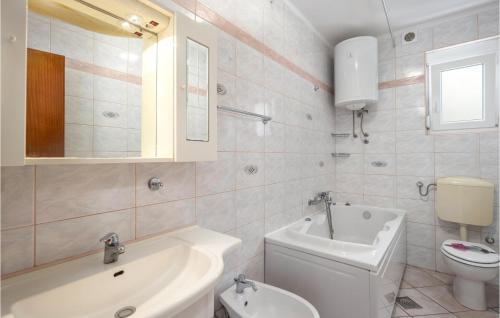 a bathroom with a sink and a toilet and a tub at Awesome Home In Crikvenica With House Sea View in Crikvenica