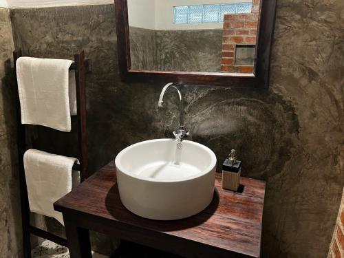 uma casa de banho com um lavatório branco numa mesa de madeira em Lao Lake House em Vientiane