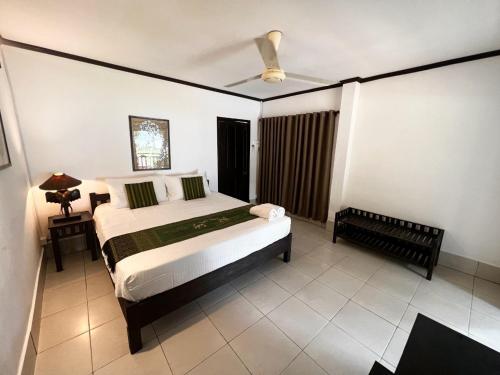 um quarto com uma cama e uma ventoinha de tecto em Lao Lake House em Vientiane