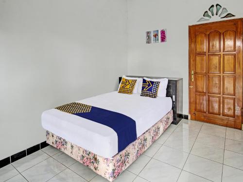 1 dormitorio con 1 cama y armario de madera en OYO 92123 Chikam House Syariah, en Kediri