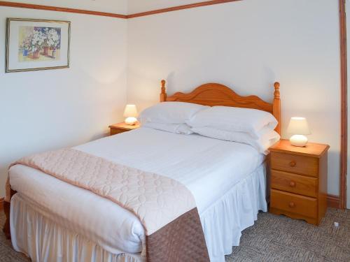 a bedroom with a large bed with two night stands at Palm Tree in Stokeinteignhead