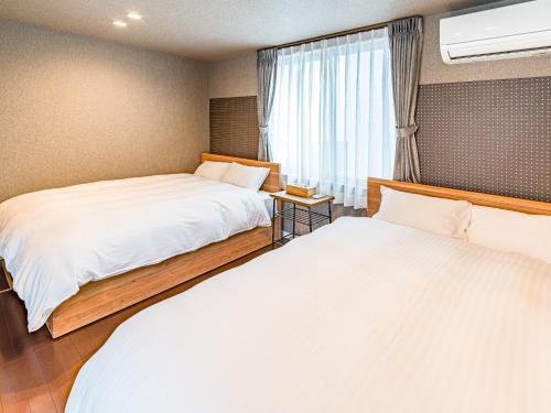 a bedroom with two beds and a window at Rakuten STAY HOUSE x WILL STYLE Matsue 102 in Matsue