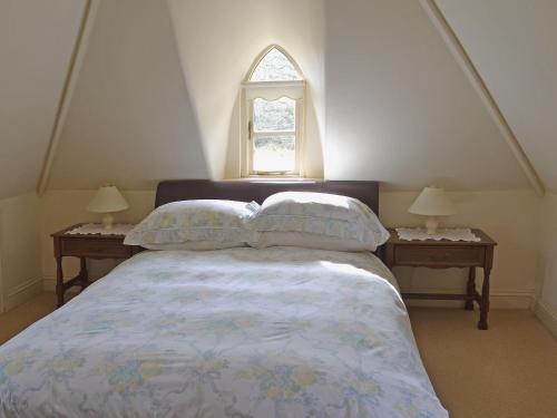 a bedroom with a bed with two nightstands and a window at Heathfield Lodge in Bransgore
