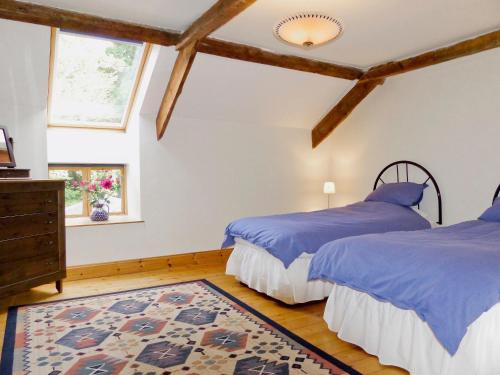 1 dormitorio con 2 camas y alfombra en Till Cottage, en Milfield