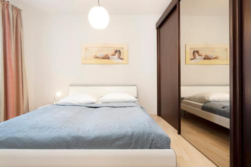 - une chambre avec un lit et un miroir dans l'établissement Ferienwohnung 18 mit Balkon im Haus Achtern Diek, à Grömitz