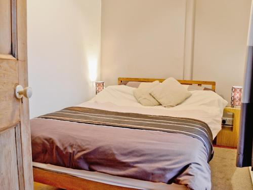 1 cama con 2 almohadas en una habitación en Is Helen Cottage, en Caernarfon