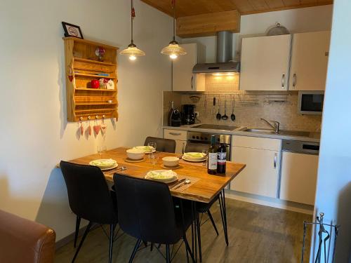 - une cuisine avec une table et des chaises en bois dans la chambre dans l'établissement Bärenhütte, à Turracher Höhe