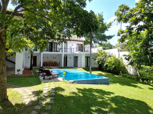 een achtertuin met een zwembad en een huis bij Villa Fauna in Ahangama