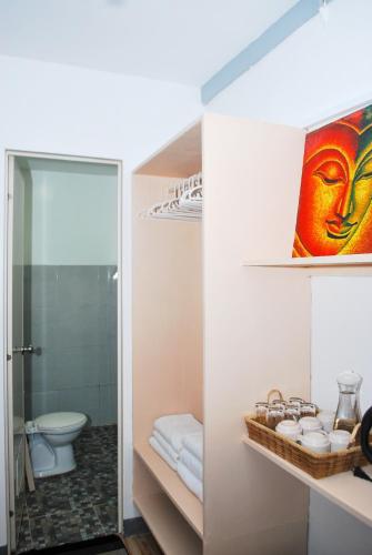 ein Bad mit einer Dusche, einem WC und einem Spiegel in der Unterkunft WOZA INN BORACAY in Boracay