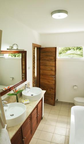 a bathroom with two sinks and a mirror at Maison D’hôtes Coignet in Rose Hill