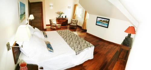 a bedroom with a white bed in a room at Maison D’hôtes Coignet in Rose Hill