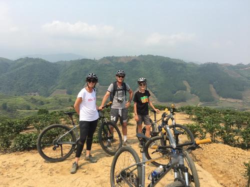 a group of people standing next to bikes on a hill at Sapa Farmstay in Sa Pa