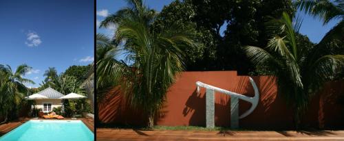 a resort with a swimming pool and a palm tree at Maison D’hôtes Coignet in Rose Hill