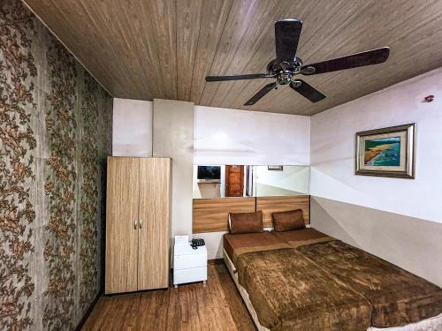a bedroom with a bed and a ceiling fan at Hotel Urban in Baguio