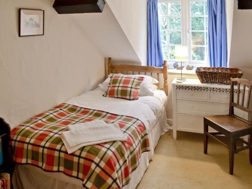 a bedroom with a bed and a chair and a window at Graig in Beaumaris