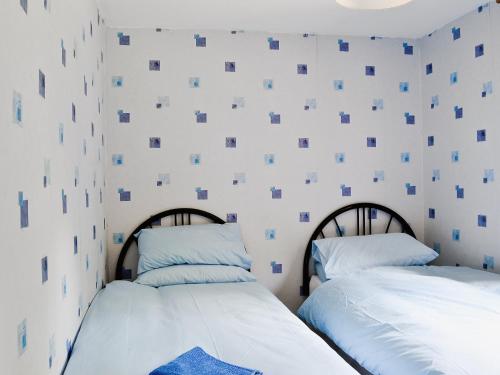 two beds sitting next to each other in a bedroom at Flowerdale Cottage in Lochgoilhead