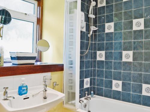W łazience znajduje się umywalka i prysznic. w obiekcie Flowerdale Cottage w mieście Lochgoilhead