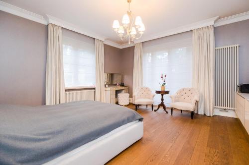 Stately Home in Magdalenka, nr Warsaw في Magdalenka: غرفة نوم بسرير وطاولة وكراسي