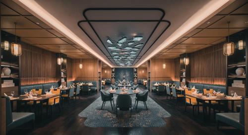 a rendering of a restaurant with tables and chairs at HUALUXE Kunshan Huaqiao by IHG - F1 Racing Preferred Hotel in Kunshan