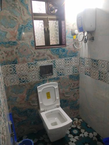 a bathroom with a toilet and a mirror at Swapnapurti Homestay in Alibaug
