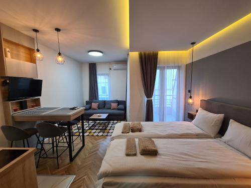 a bedroom with a large bed and a living room at Apartmani Central & Free parking in Vrnjačka Banja