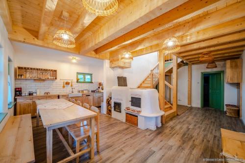 uma grande cozinha com pisos e tectos em madeira em Dimineți în Cerdac em Piatra Neamţ
