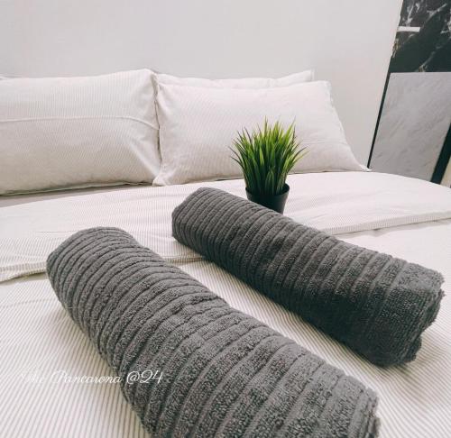 a bed with two gray pillows on top of it at The Pancarona24 Homestay forMuslim in Ipoh