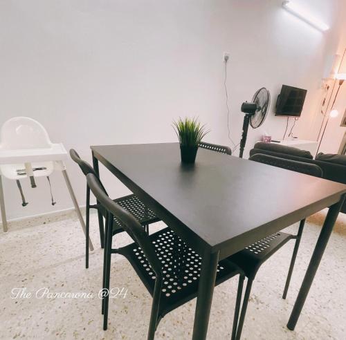 a dining room table with chairs and a plant on it at The Pancarona24 Homestay forMuslim in Ipoh