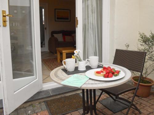 a table with a plate of fruit on it at Bellagio in Padstow